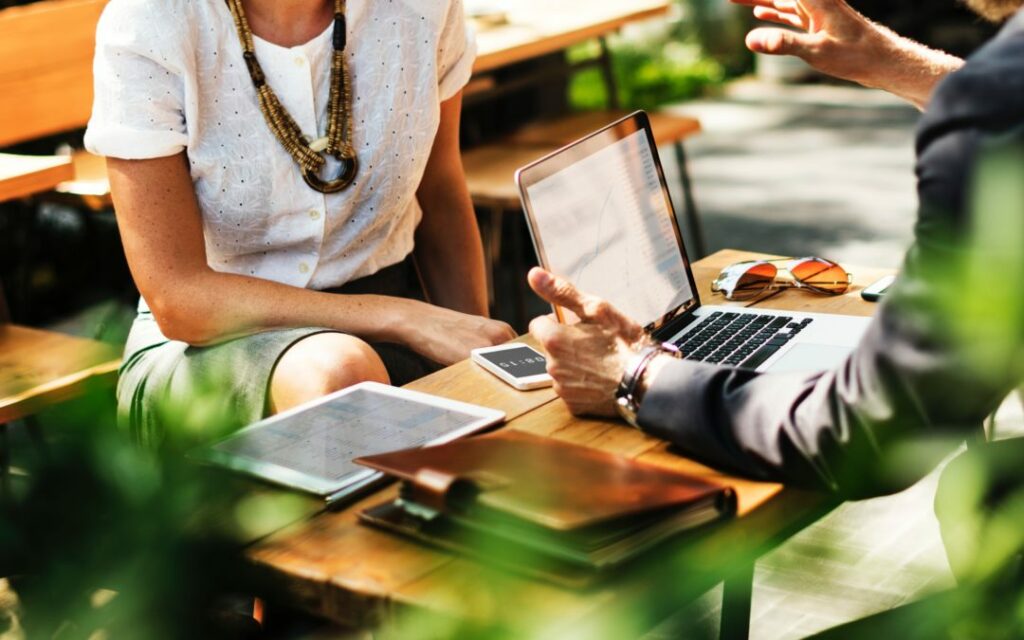 Human beings using digital tools while meeting in a face-to-face, laid back manner